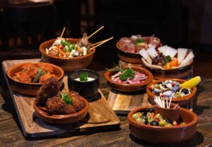 Assorted Spanish tapas dishes served in rustic style on a wooden table.