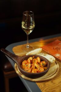 Savor a shrimp and wine pairing at a cozy restaurant setting, perfect for gourmet dining experiences.